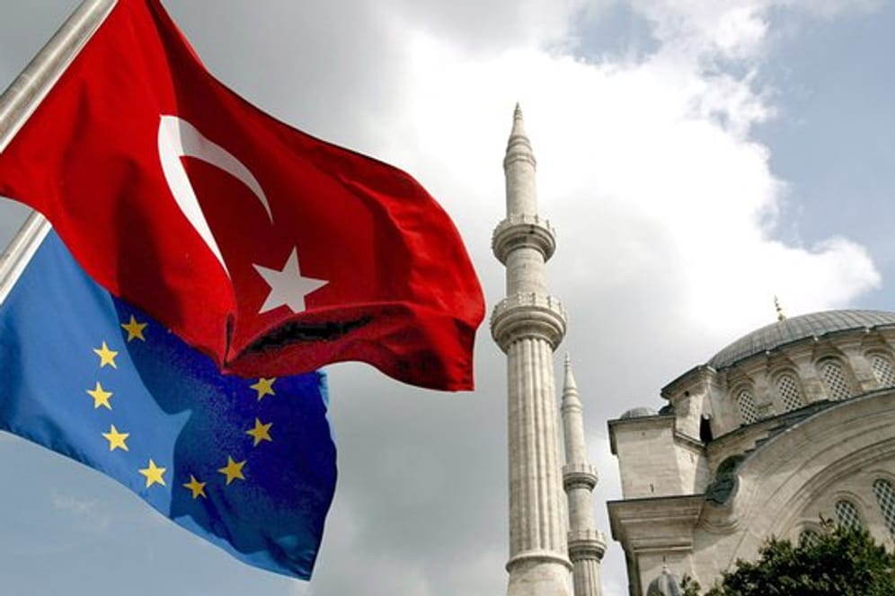 Eine EU-Flagge und eine türkische Flagge wehen vor einer Moschee in Istanbul.