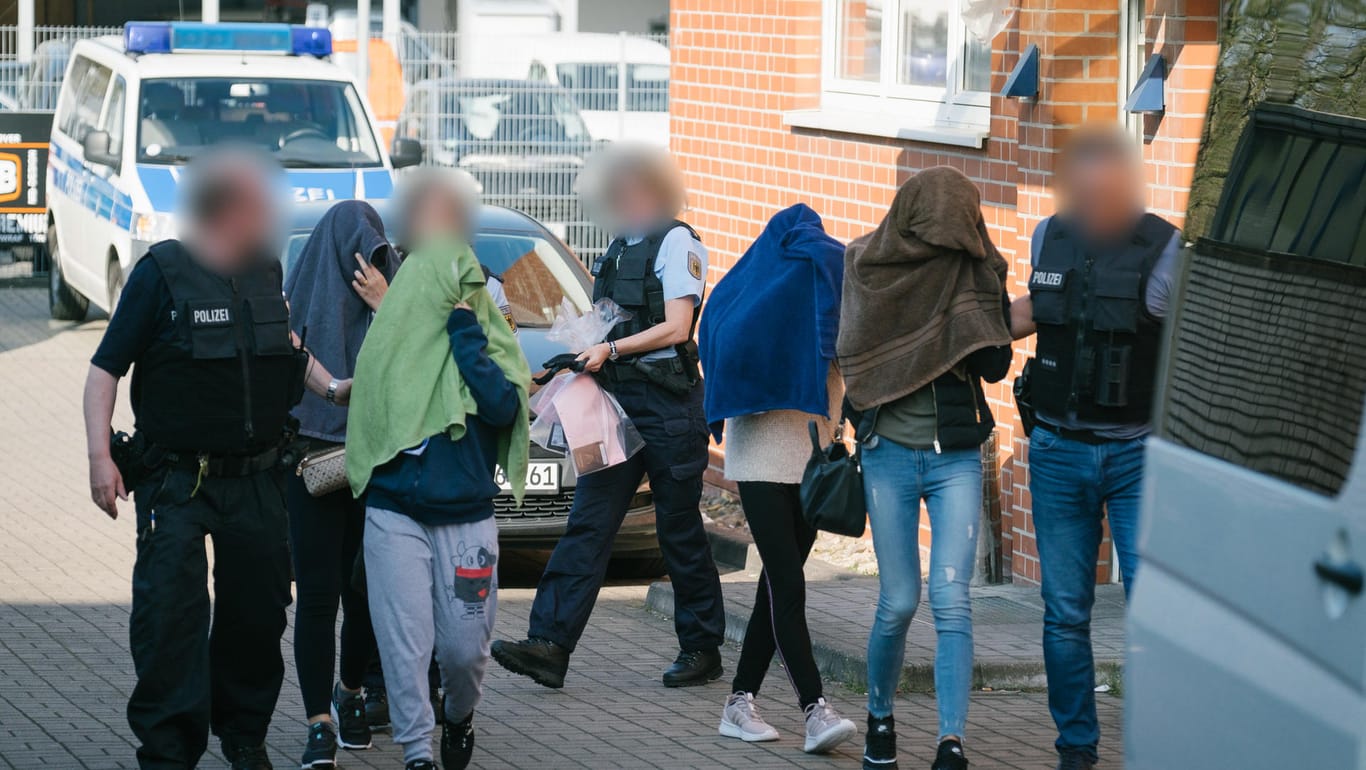 Polizisten führen Frauen aus einem Haus im Hannoveraner Stadtteil Anderten: Die Staatsanwaltschaft ermittelt insgesamt gegen 56 Personen im Alter zwischen 26 und 66 Jahren.