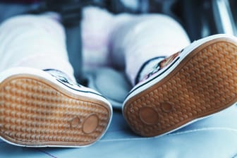 Kinderfüße in einem Wagen.