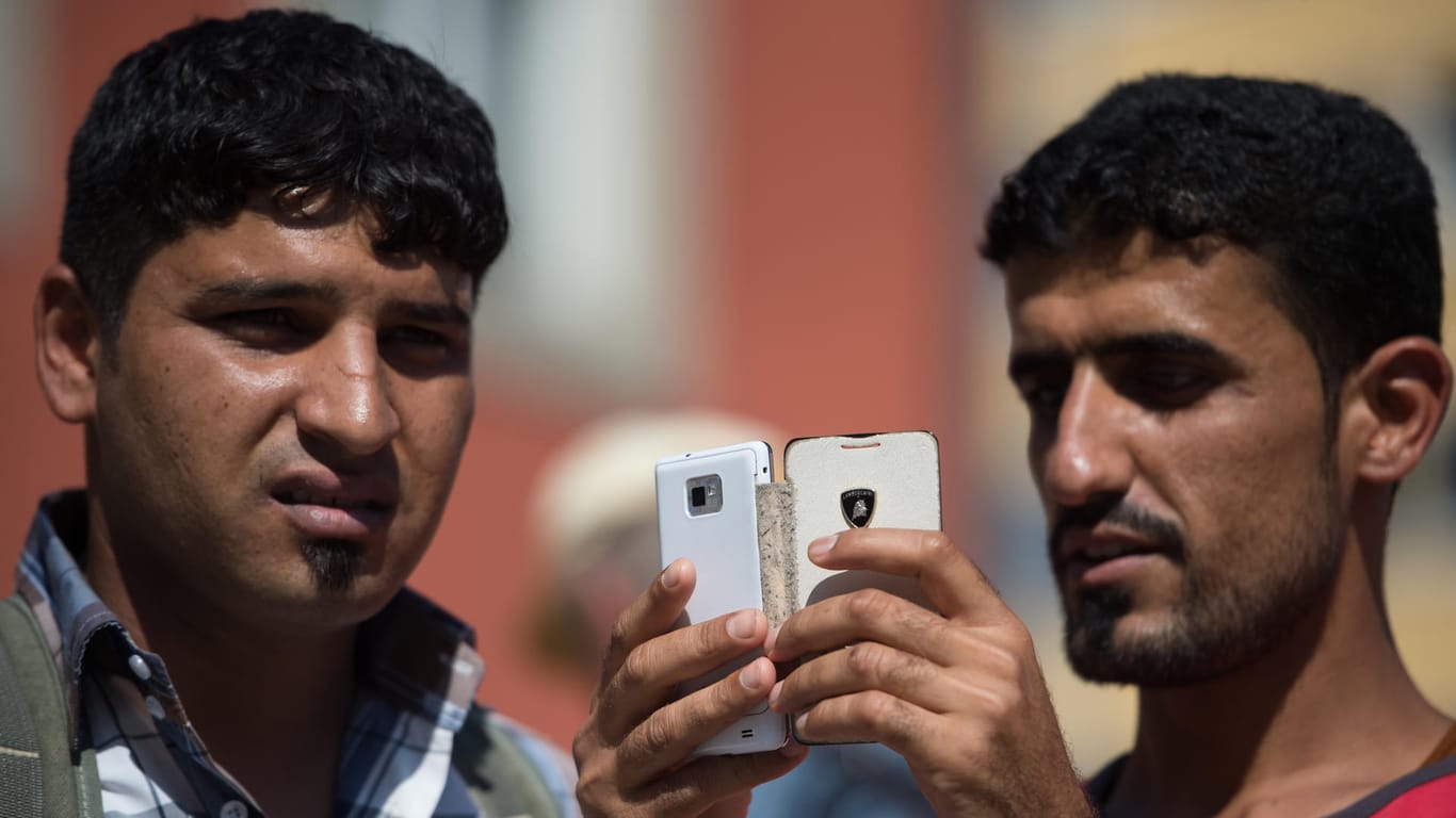 Flüchtlinge bedienen ihr Handy: In Österreich soll das Asylrecht erheblich verschärft werden.