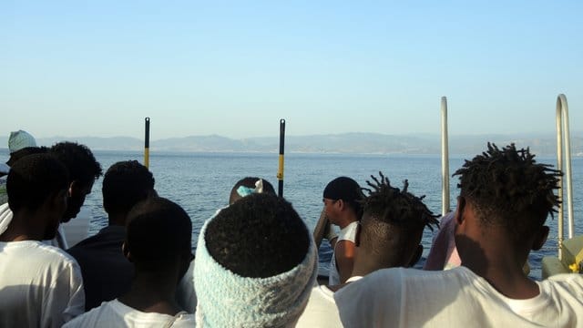 Europa in Sicht: Aus dem Mittelmeer gerettete Flüchtlinge auf einem Rettungsschiff vor der italienischen Küste. Europa in Sicht: Aus dem Mittelmeer gerettete Flüchtlinge auf einem Rettungsschiff vor der italienischen Küste.
