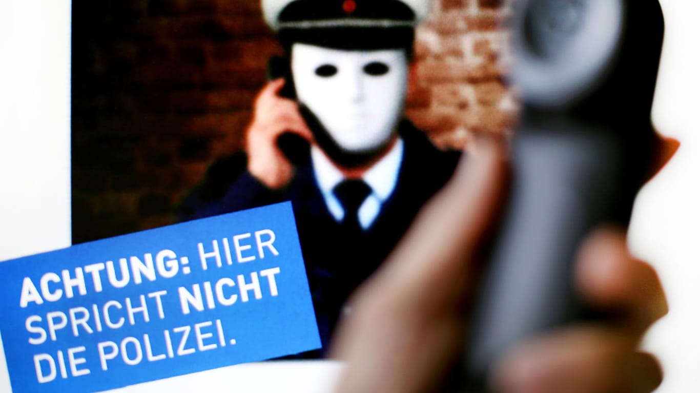 Ein Telefonhörer vor einem Plakat der Polizei NRW: Betrüger, die sich als Polizisten ausgeben, gibt es immer wieder.