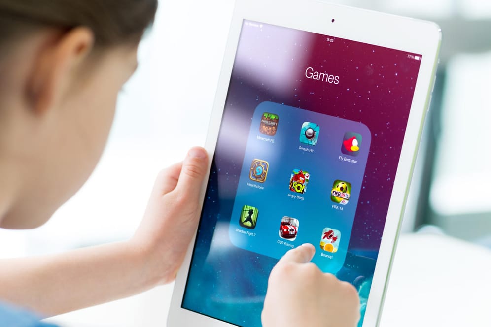 Ein Kind mit Tablet in der Hand: Bei Apps für Kinder sollten Eltern unter anderem die Menge an Werbung und den Datenschutz kontrollieren.