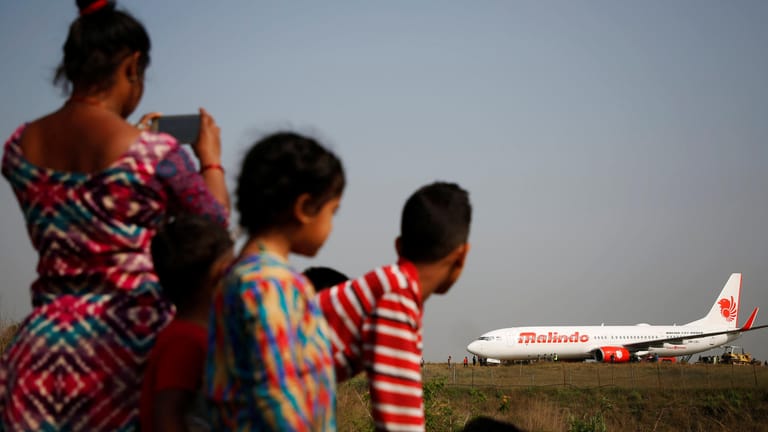 Menschen in Kathmandu begutachten den Flieger von Malindo Air: Das Flugzeug war beim Startversuch auf eine Rasenfläche gerutscht.