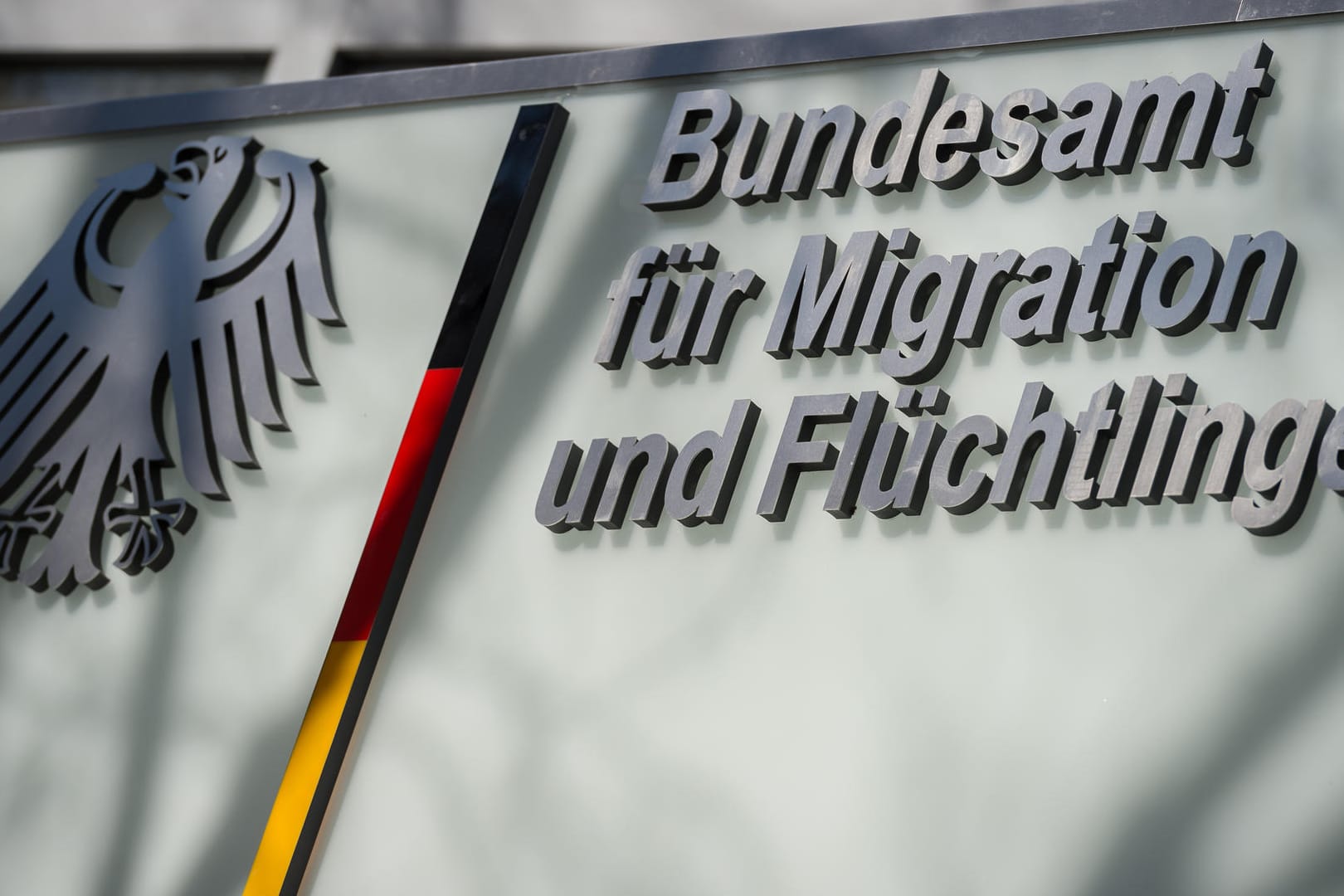 Das Logo des Bundesamts für Migration und Flüchtlinge (BAMF) in Berlin: Einem Medienbericht zufolge soll eine Mitarbeiterin Asylbescheide unrechtmäßig positiv beschieden haben.