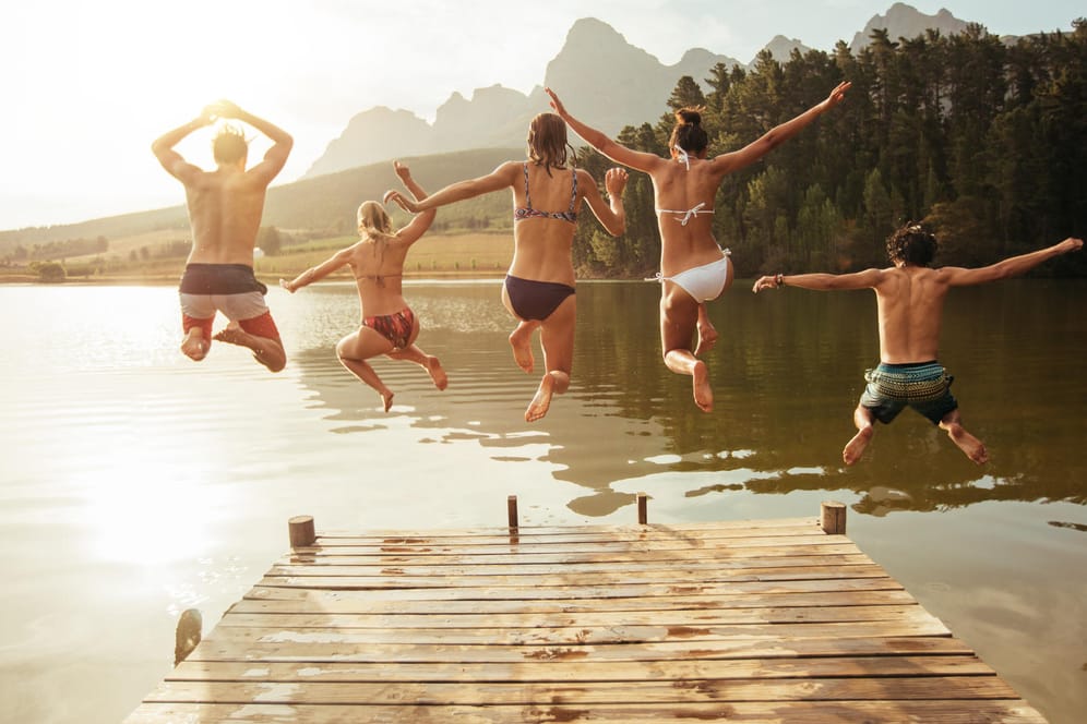 Junge Leute springen in einen See: Wo kann man in Deutschland am besten schwimmen gehen?
