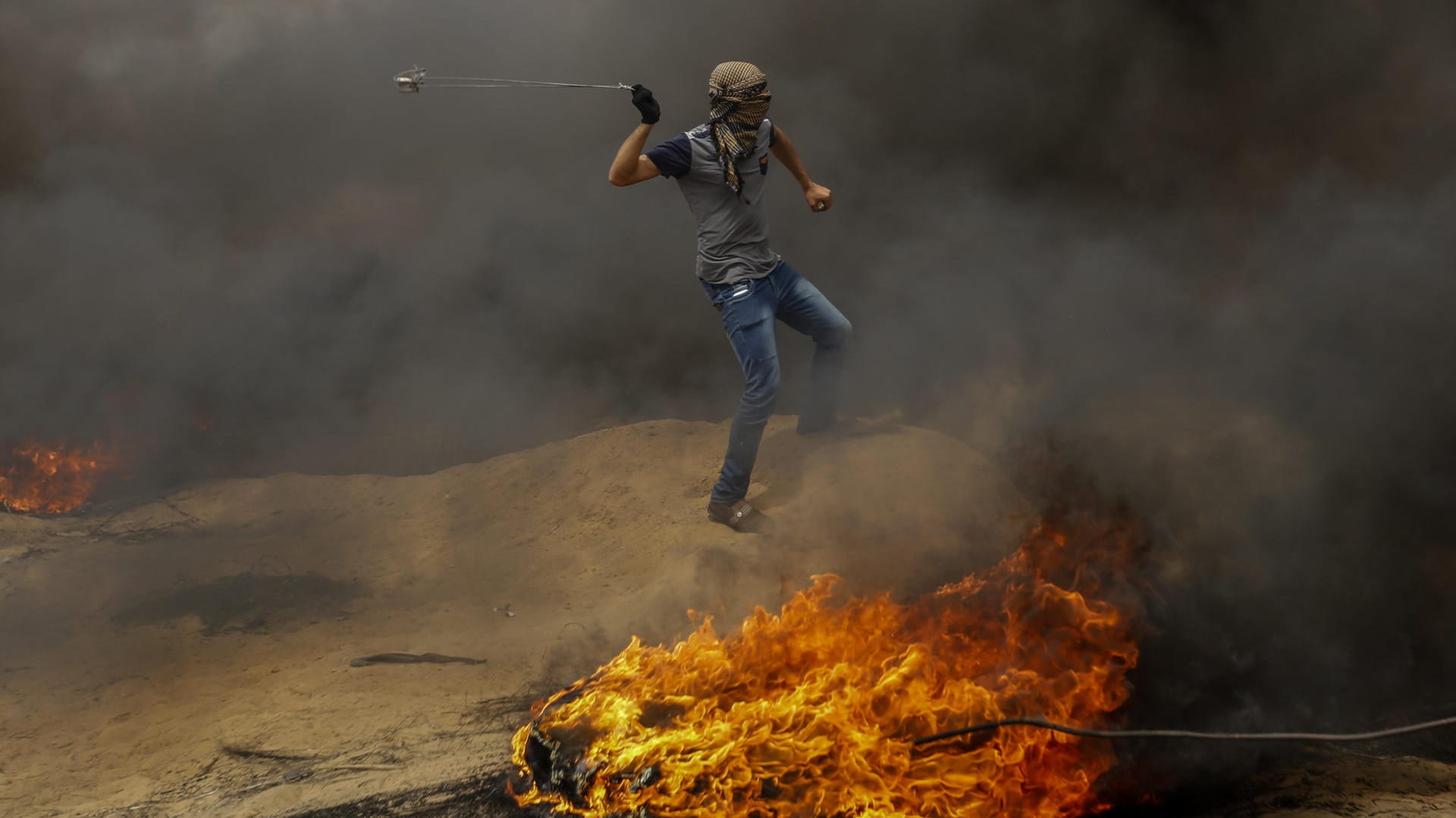 Ein palästinensischer Mann zielt während eines Protests an der Grenze zu Israel mit einer Steinschleuder: In den vergangenen Wochen wurden 37 Menschen getötet. Ein palästinensischer Mann zielt während eines Protests an der Grenze zu Israel mit einer Steinschleuder: In den vergangenen Wochen wurden 37 Menschen getötet.