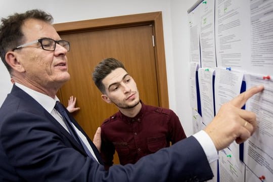 Entwicklungsminister Gerd Müller schaut sich nach der Eröffnung des Migrationsberatungszentrum in Erbil mit einem aus Deutschland zurückgekehrten Flüchtling Jobangebote an.