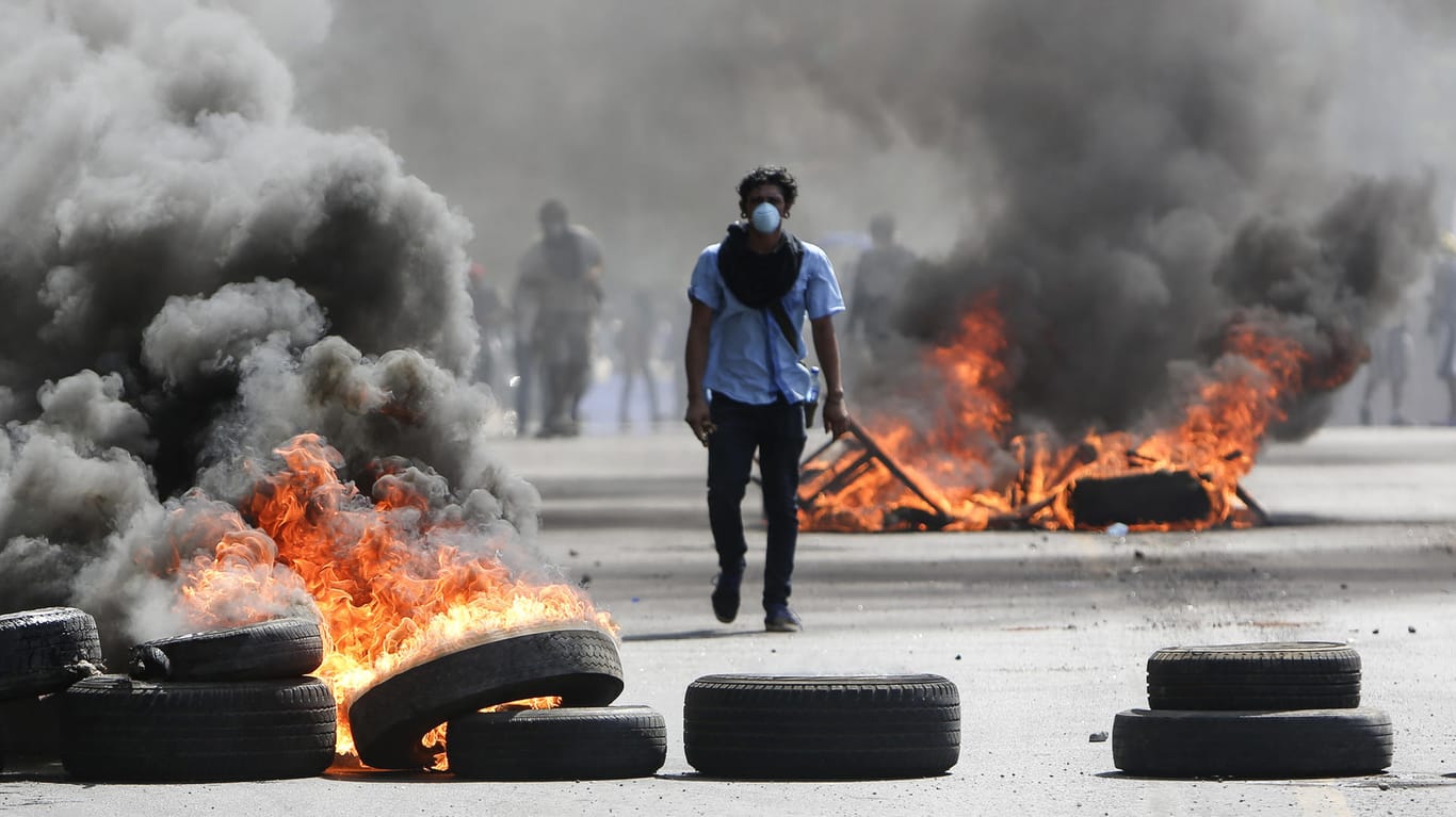 Proteste in Nicaragua: Ein maskierter Demonstrant läuft zwischen brennenden Barrikaden. Die Proteste dauern schon drei Tage an.