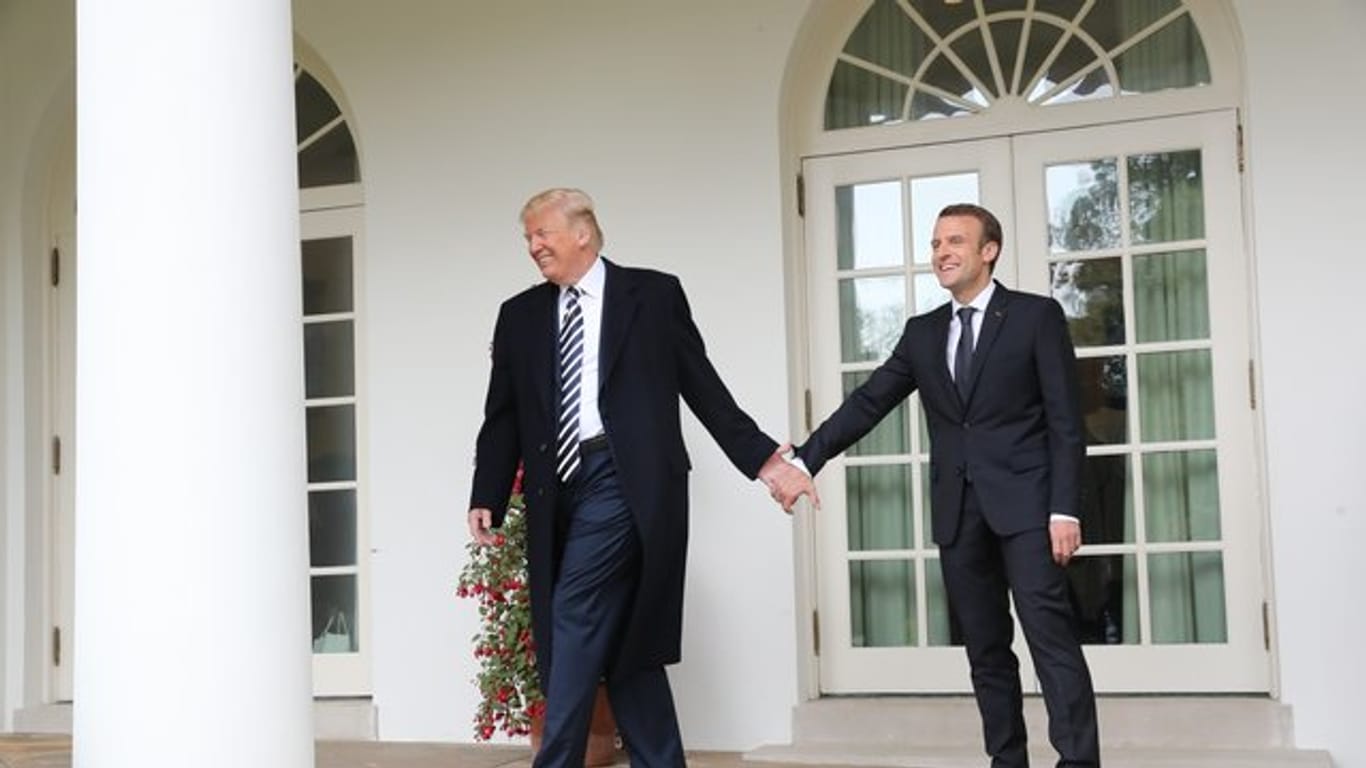 Donald Trump und Emmanuel Macron gehen Hand in Hand zum Oval Office im Weißen Haus.