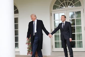 Donald Trump und Emmanuel Macron gehen Hand in Hand zum Oval Office im Weißen Haus.