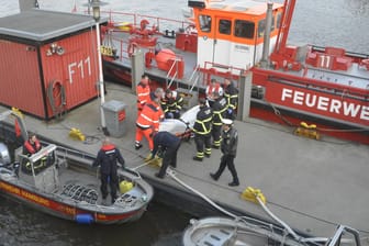 Hamburg: Eine Leiche wird von einem Boot der Feuerwehr Hamburg auf einen Steg im Hafen getragen. Bei der am Montagmorgen aus der Elbe in der Hamburger Hafencity geborgenen Leiche handelt es sich mit hoher Wahrscheinlichkeit um den vermissten Schotten Liam Colgan.