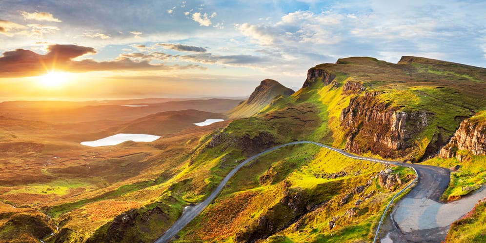 Die Quiraing Road: Der Roadtrip auf Schottlands Insel Isle of Skye begeistert durch satte grüne Hügel, die sich bis zum Ozean schlängeln.