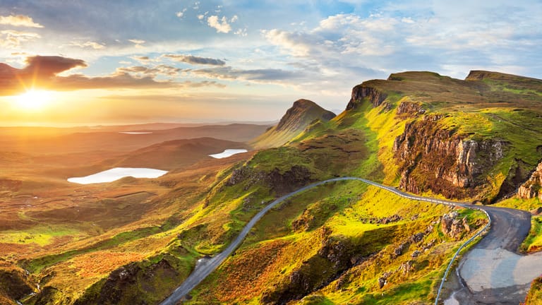 Die Quiraing Road: Der Roadtrip auf Schottlands Insel Isle of Skye begeistert durch satte grüne Hügel, die sich bis zum Ozean schlängeln.