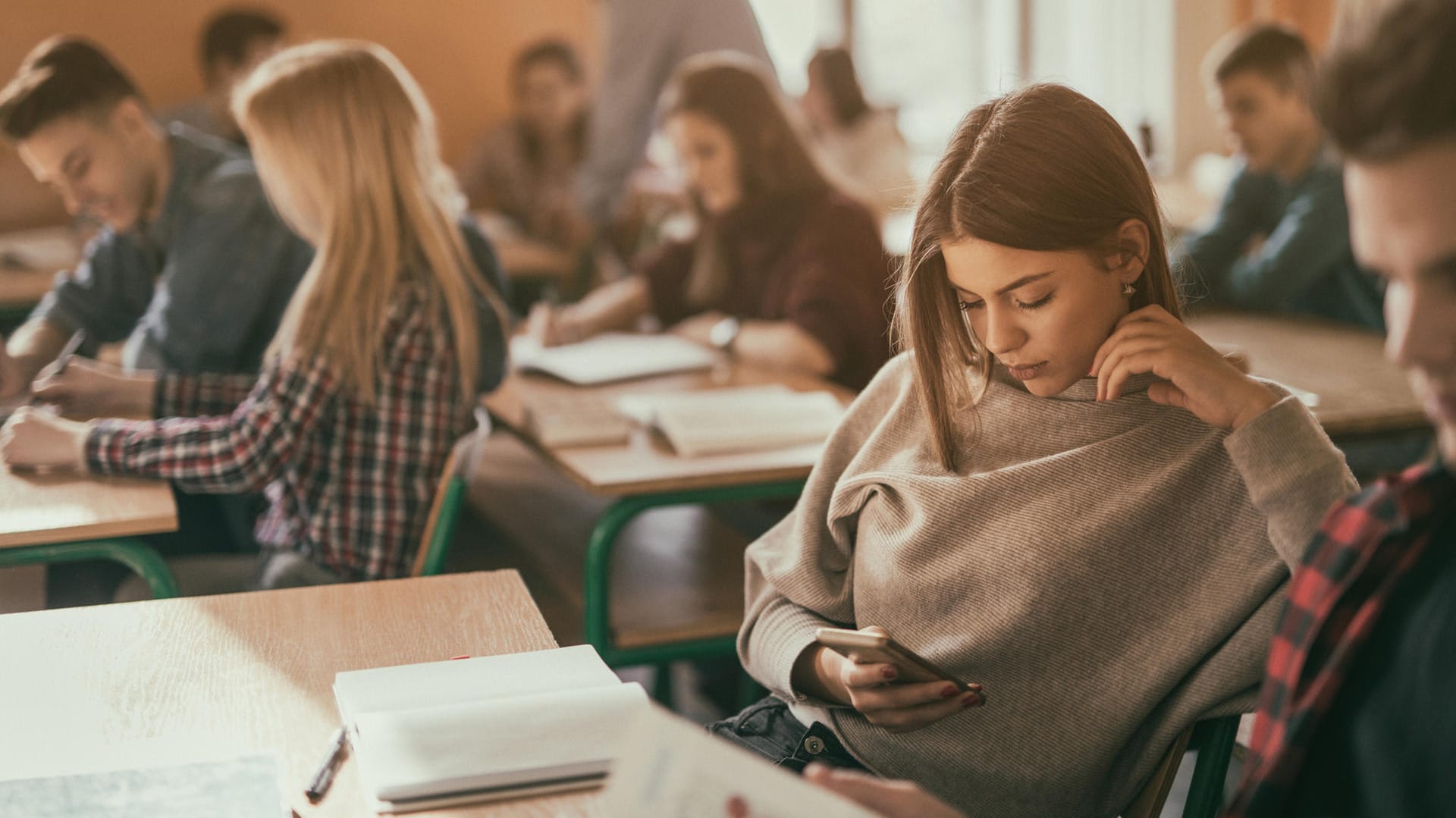 Schülerin mit Smartphone: Ob Handys auf dem Schulgelände oder im Unterricht erlaubt sind, entscheiden die Schulen.