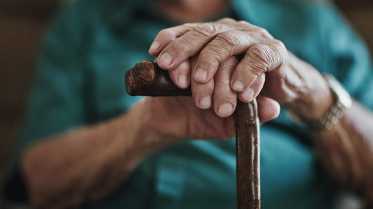 Mann stützt seine Hände auf einen Gehstock: Über die Sozialversicherungsbeiträge zahlen Arbeitnehmer in die gesetzliche Rente ein. Dabei finanzieren die derzeit Beschäftigten die aktuelle Rentengeneration.