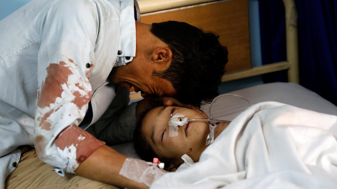 In einem Krankenhaus in Kabul weint ein Mann am Bett eines verletzten Mädchens: Bei einem Selbstmordanschlag des IS wurden in Kabul am Sonntag mindestens 57 Menschen getötet.