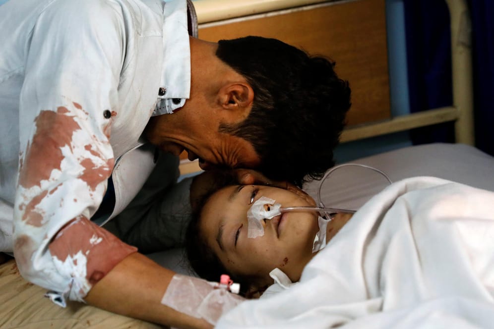 In einem Krankenhaus in Kabul weint ein Mann am Bett eines verletzten Mädchens: Bei einem Selbstmordanschlag des IS wurden in Kabul am Sonntag mindestens 57 Menschen getötet.