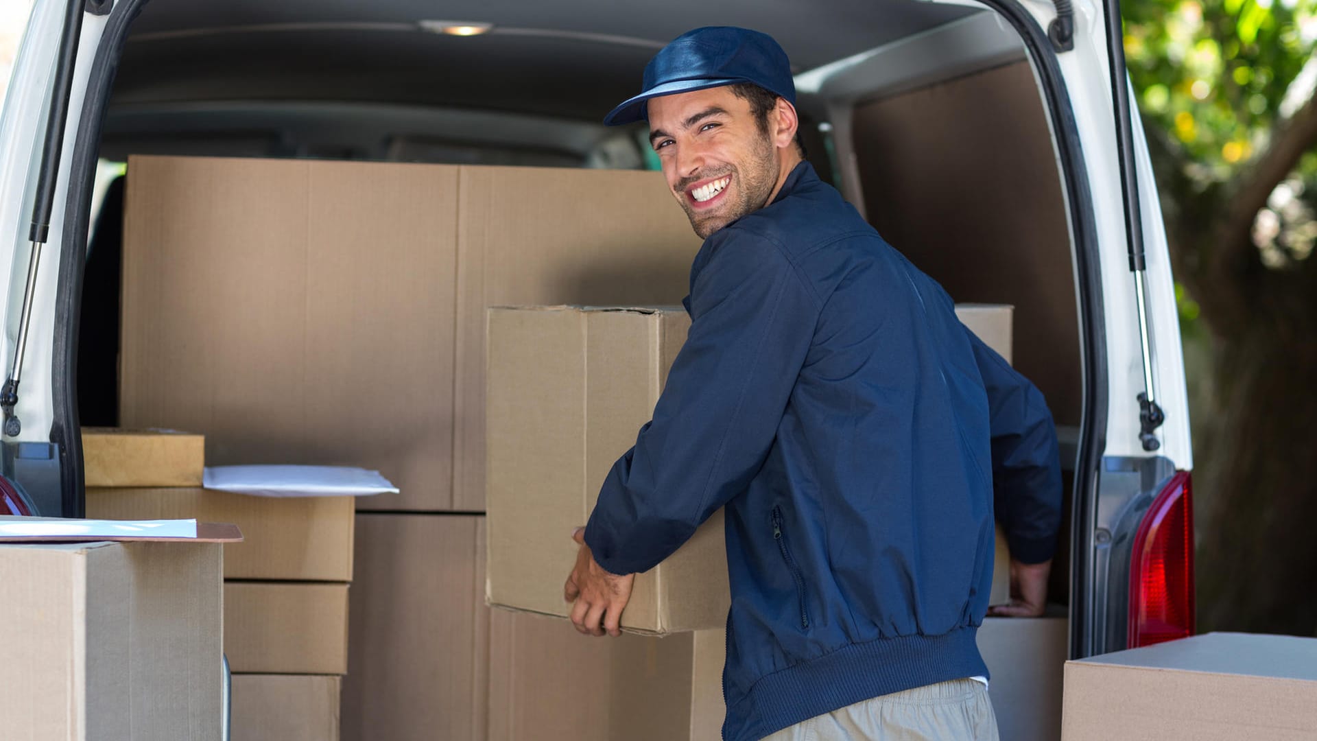 Paketbote mit Paketen im Auto