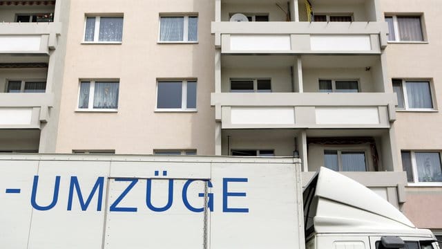 Der Lkw einer Umzugsfirma steht vor einem Wohnhaus.