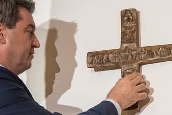 Ministerpräsident hängt im Eingangsbereich der bayerischen Staatskanzlei ein Kreuz auf.