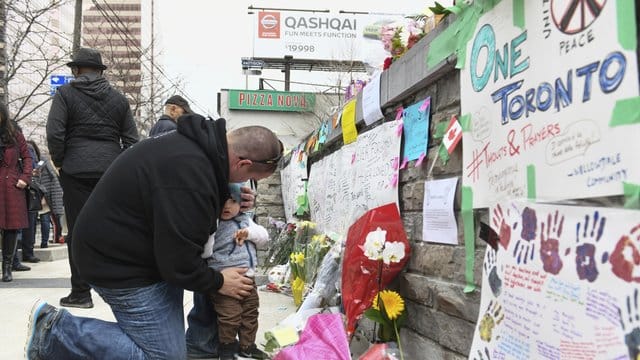 An einer provisorischen Erinnerungsstätte in Toronto gedenken Passanten der Opfer der Todesfahrt. An einer provisorischen Erinnerungsstätte in Toronto gedenken Passanten der Opfer der Todesfahrt.