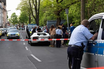 Die Polizei sichert den Tatort der Schießerei in Köln, bei der zwei Männer schwer verletzt wurden: Einer der Männer soll der Chef der Rockergruppe "Bandidos" sein. Ihm soll auch der weiße Lamborghini gehören.