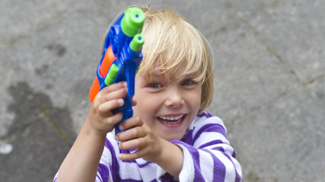 Kleines Mädchen spielt mit Wasserpistole. Google will sein Pistolen-Emoji gegen eine Spielzeugwaffe eintauschen.