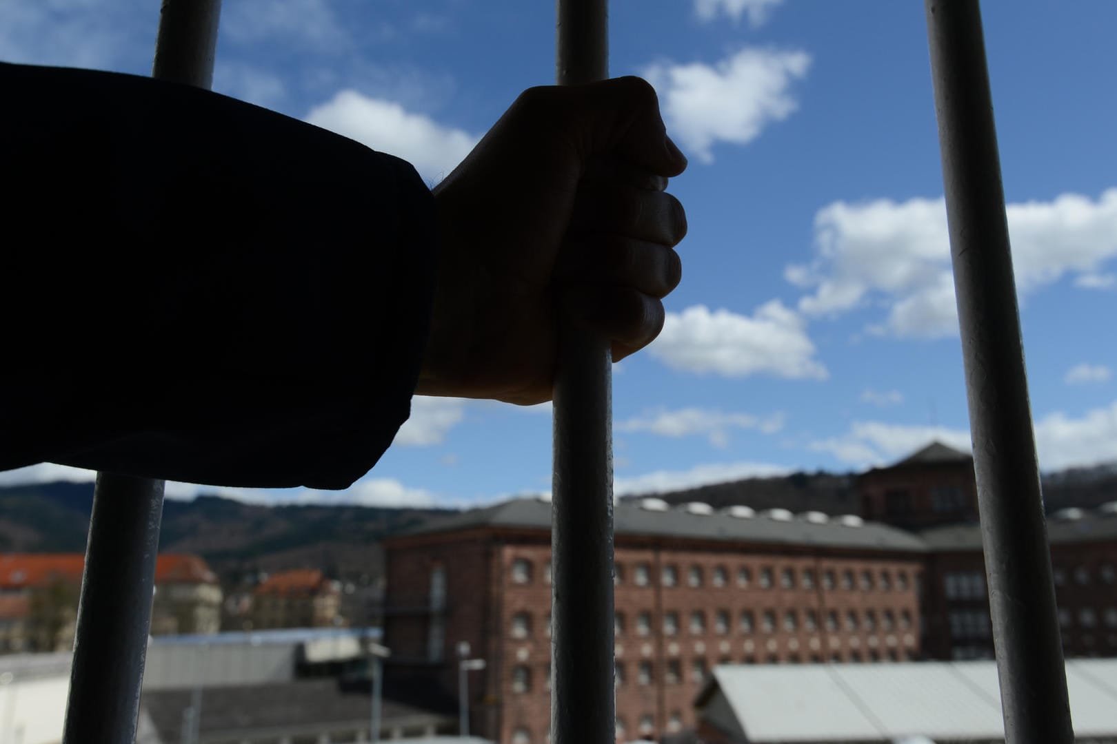 Ein Mann steht in der Justizvollzugsanstalt in Freiburg vor einem vergitterten Fenster: Die deutschen Gefängnisse sind überlastet.