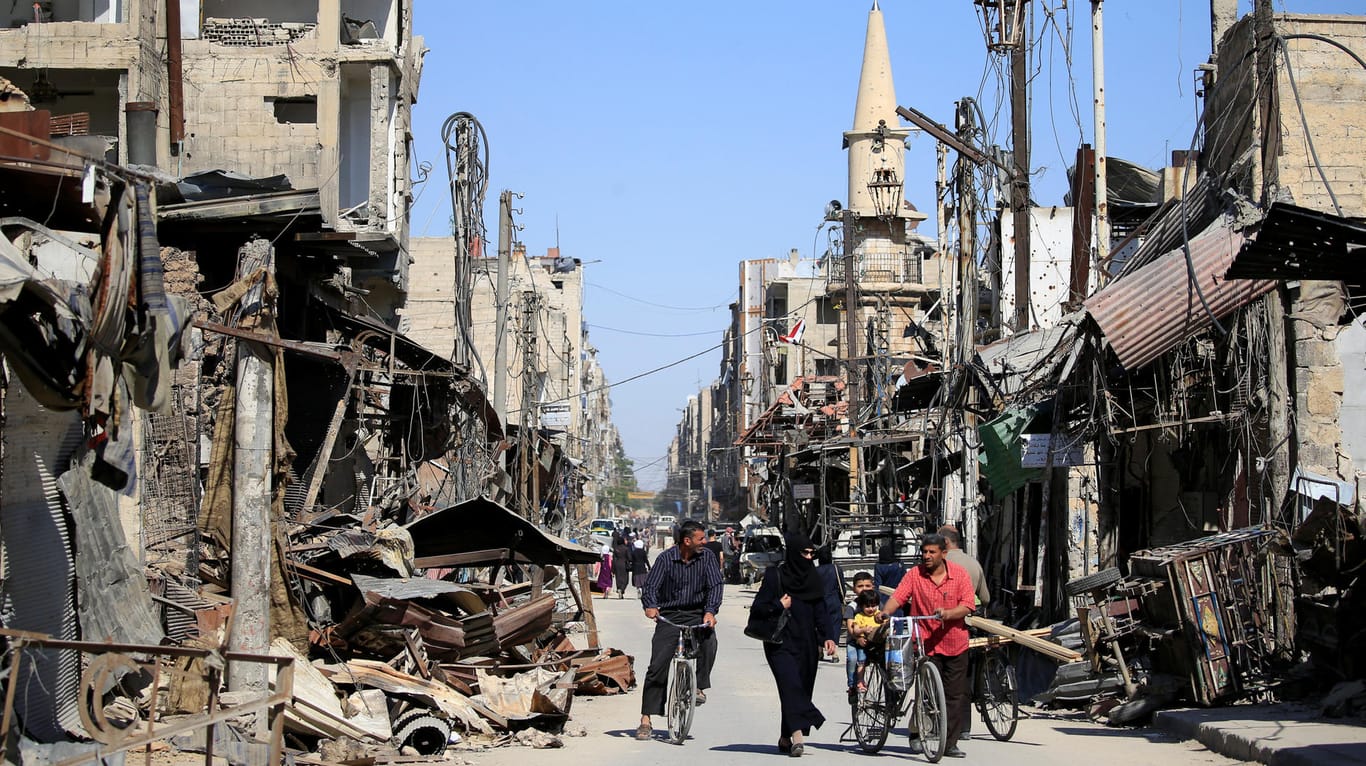 Menschen in den Straßen der zerstörten Stadt Duma in Syrien: Frieden hat die Brüsseler Syrien-Konferenz nicht gebracht. Aber immerhin Geld für die Menschen.