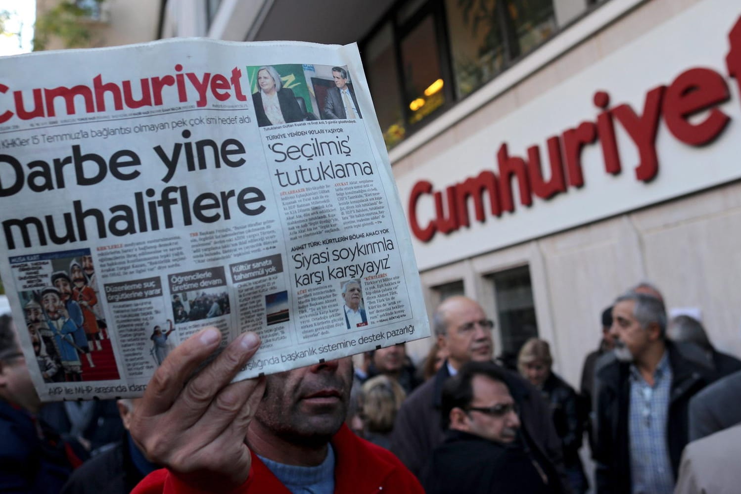 Ein Mann hält eine Ausgabe der Zeitung vor der "Cumhuriyet"-Zentrale in Istanbul (Türkei) in die Luft: Mehrere führende Mitarbeiter der Zeitung haben in der Türkei mehrjährige Haftstrafen erhalten. (Archivbild)