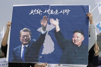 Nordkoreas Machthaber Kim Jong Un (r) und der südkoreanische Präsident Moon Jae sind in Seoul auf einem Plakat von Aktivisten zu sehen.