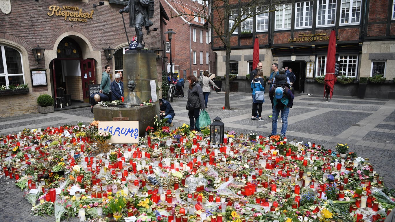 Der Ort der Amokfahrt von Münster: Ein Schild mit der Aufschrift "Warum?" steht inmitten von Blumen und Kerzen vor dem Restaurant "Großer Kiepenkerl".