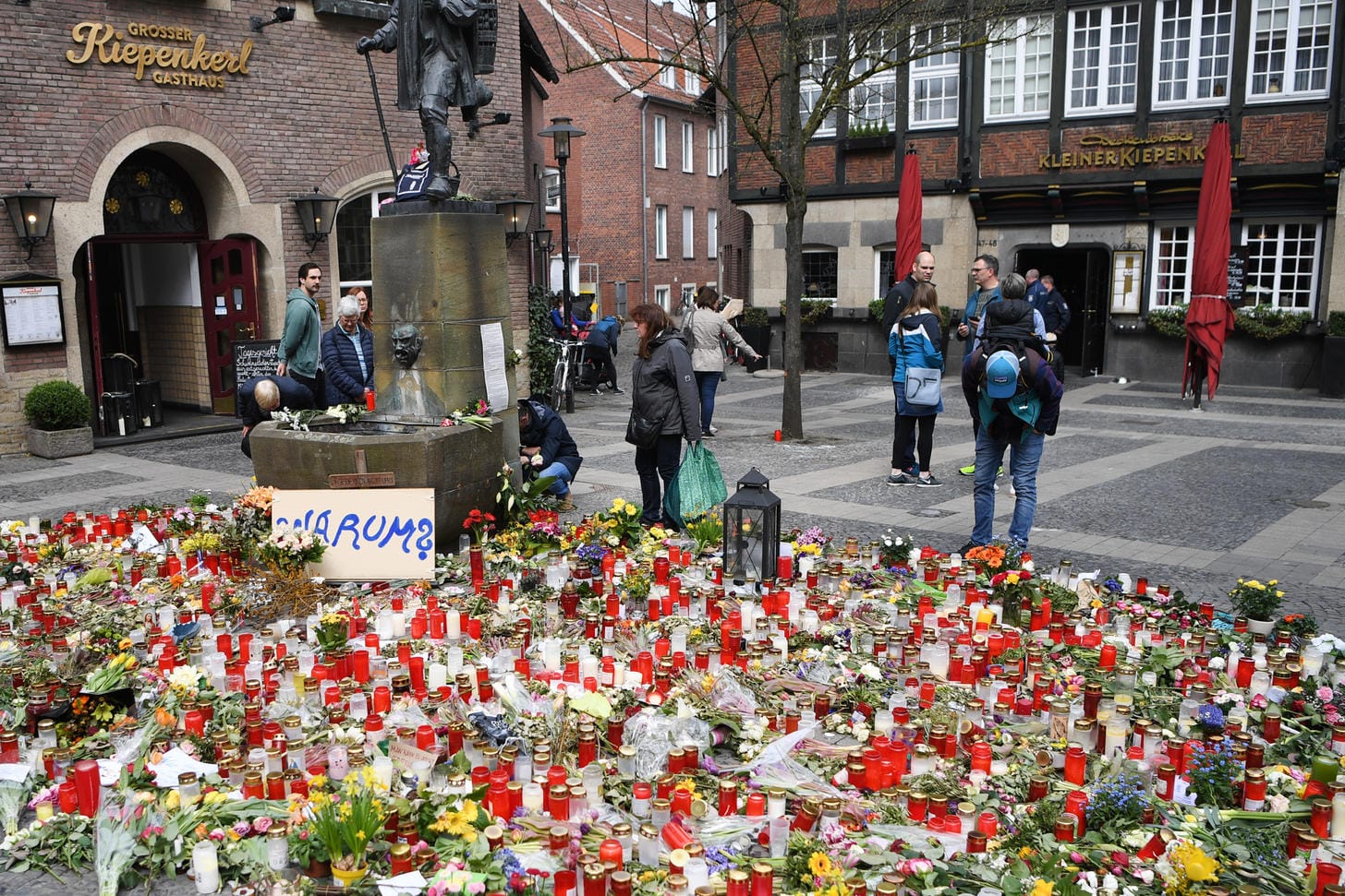 Der Ort der Amokfahrt von Münster: Ein Schild mit der Aufschrift "Warum?" steht inmitten von Blumen und Kerzen vor dem Restaurant "Großer Kiepenkerl".