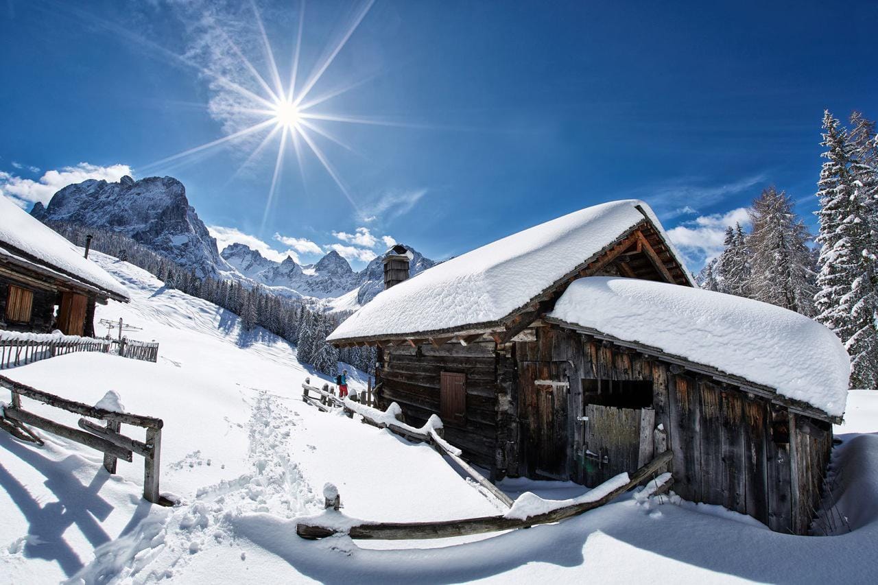Verschneite Hütte in den Bergen: ein Urlaubserlebnis in abgeschiedener Natur.