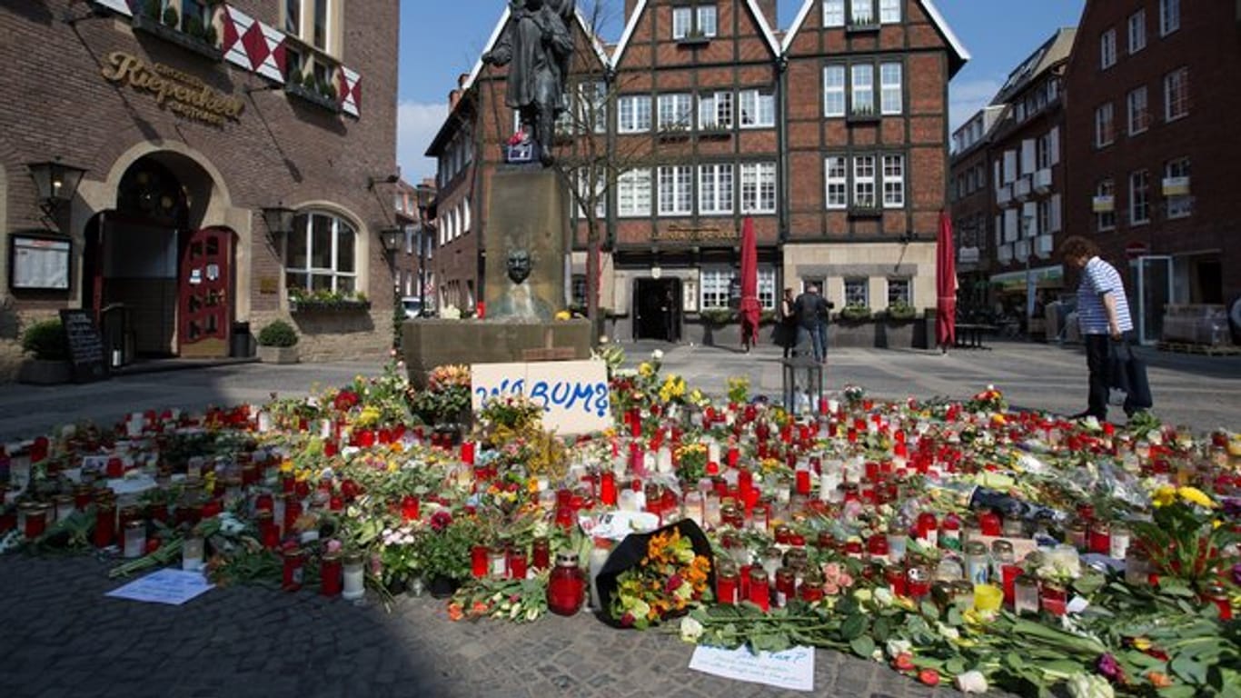Trauerkerzen und Blumen liegen vor dem Unglücksort in Münster.