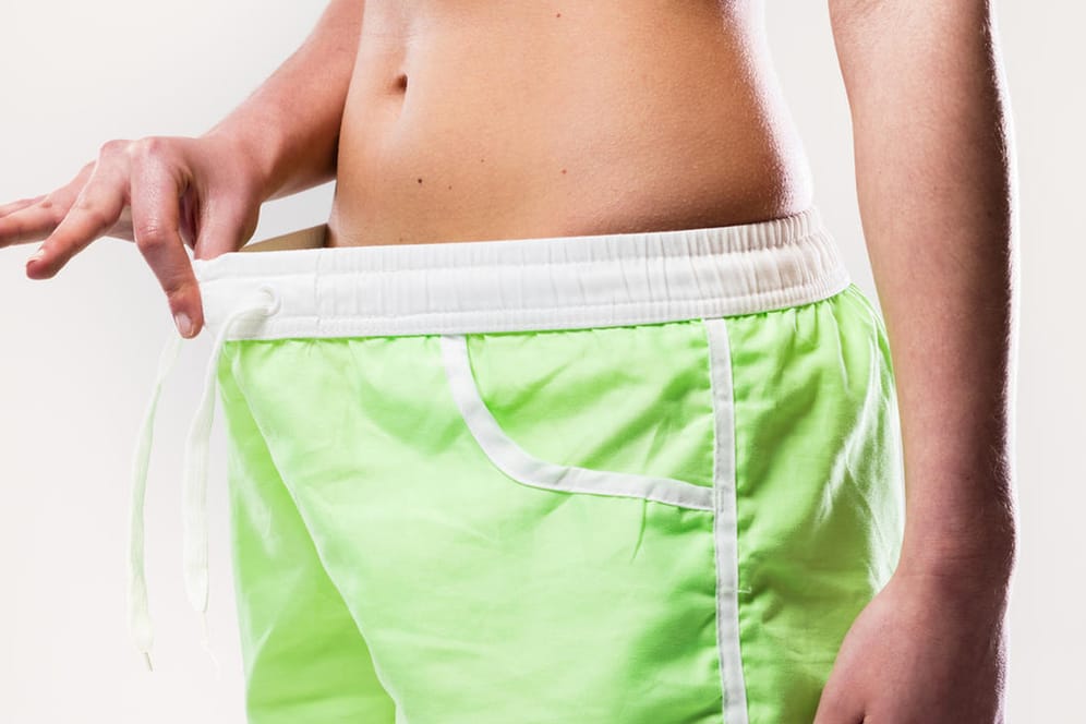 Eine Frau blickt in ihre Shorts.
