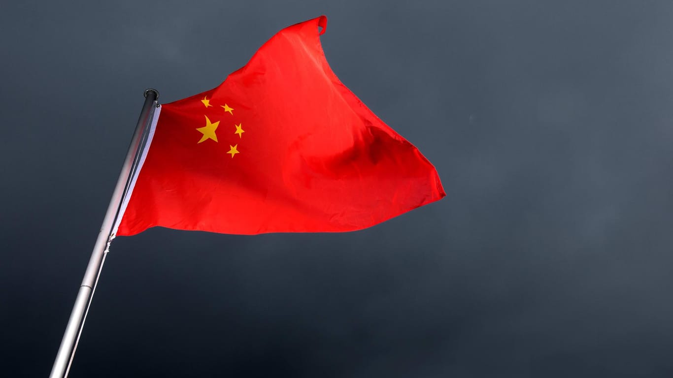 Die Flagge Chinas weht im Wind vor schwarz-grauem Himmel: Ein Messerstecher tötete sieben Kinder auf dem Heimweg von der Schule.