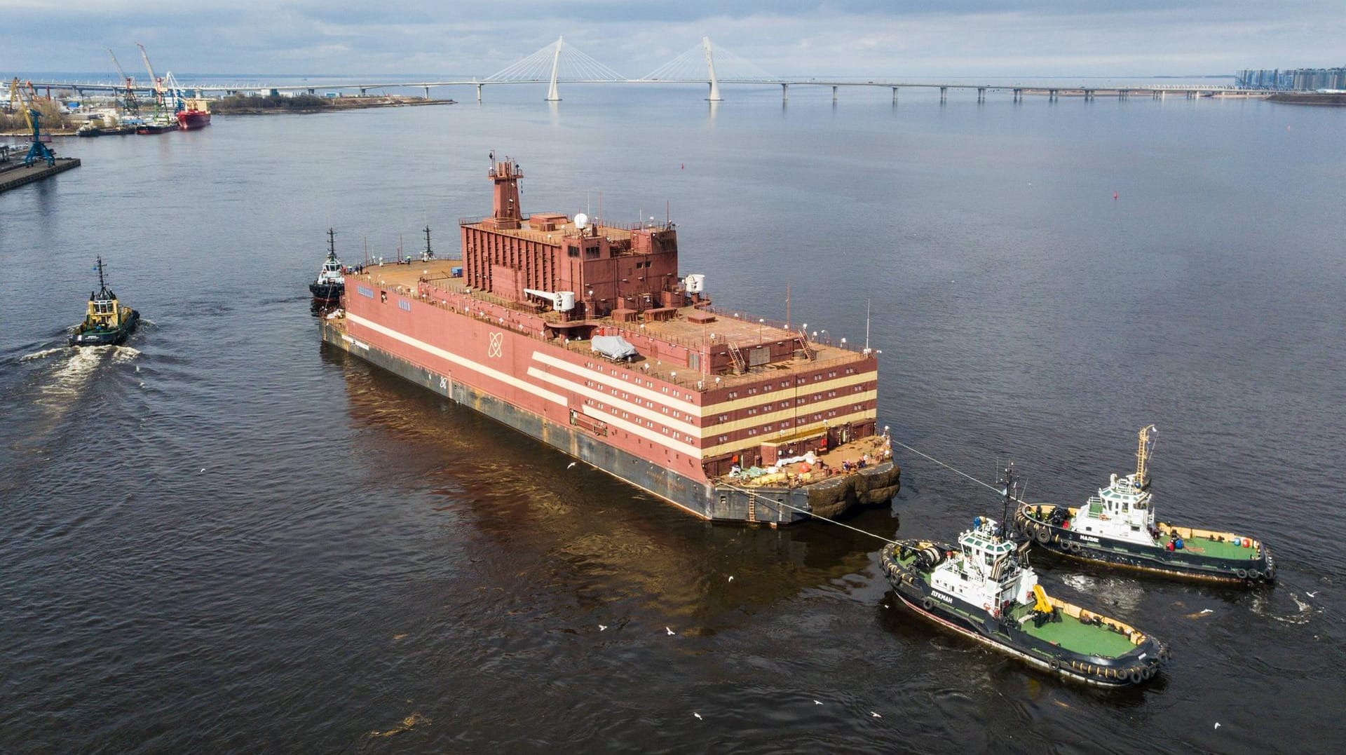 Schlepper ziehen das schwimmende Atomkraftwerk aus dem Hafen: Umweltschützer protestieren vehement gegen das Projekt.