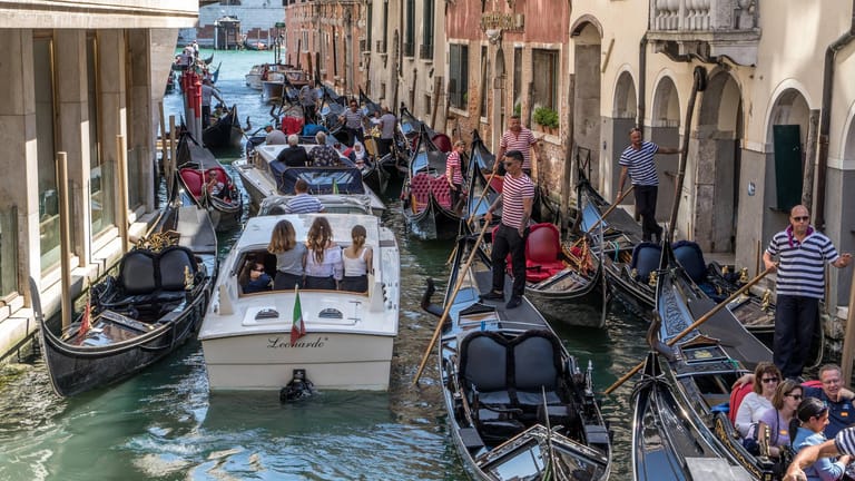 Gondoliere auf Gondeln mit Touristen im Kanal in Venedig