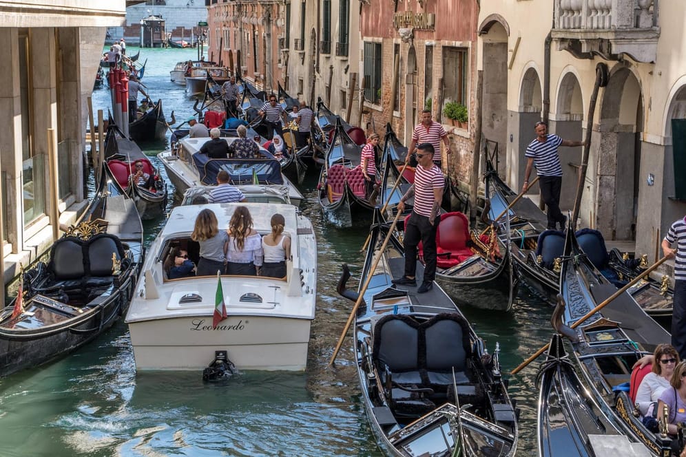Gondoliere auf Gondeln mit Touristen im Kanal in Venedig