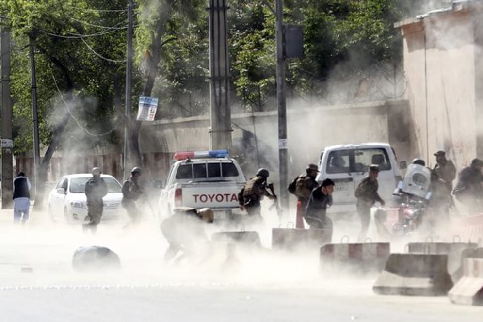Sicherheitskräfte und Zivilisten rennen während einer Explosion in der afghanischen Hauptstadt Kabul.