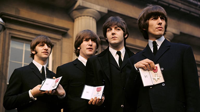 Ringo Starr, John Lennon, Paul McCartney und George Harrison zeigen ihre Orden, mit denen sie Königin Elisabeth II. 1965 auszeichnete: Das Genie der Beatles lässt sich auf eine Formel herunterbrechen, behauptet der kanadische Autor Malcolm Gladwell.