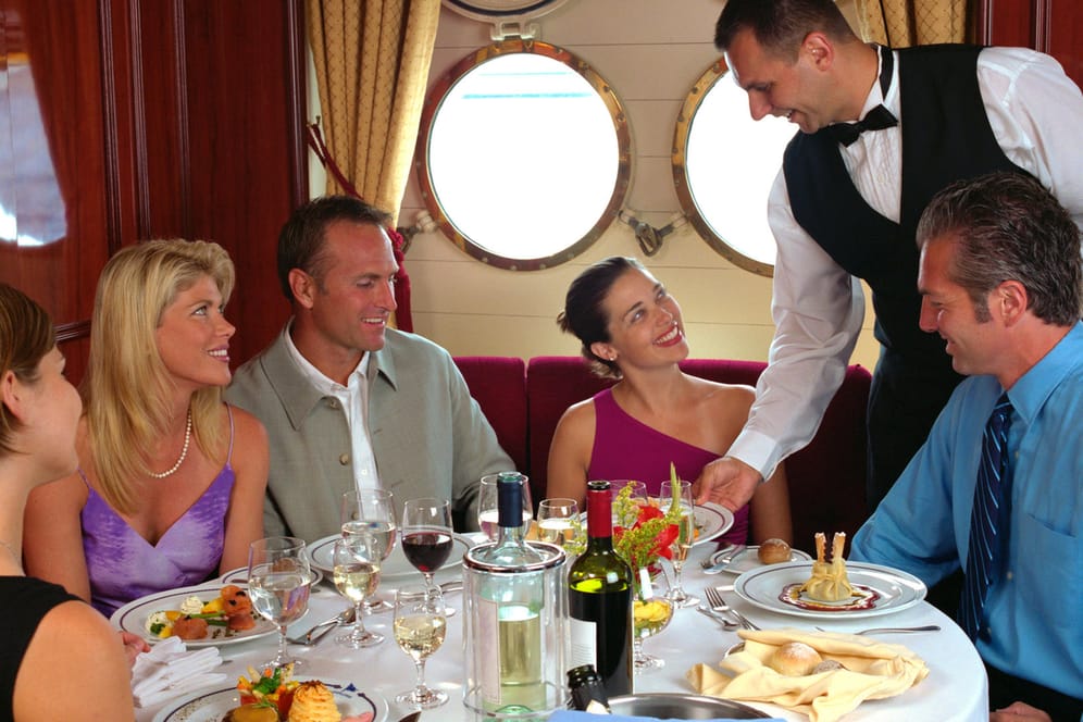 Menschen essen auf einem Schiff am Tisch
