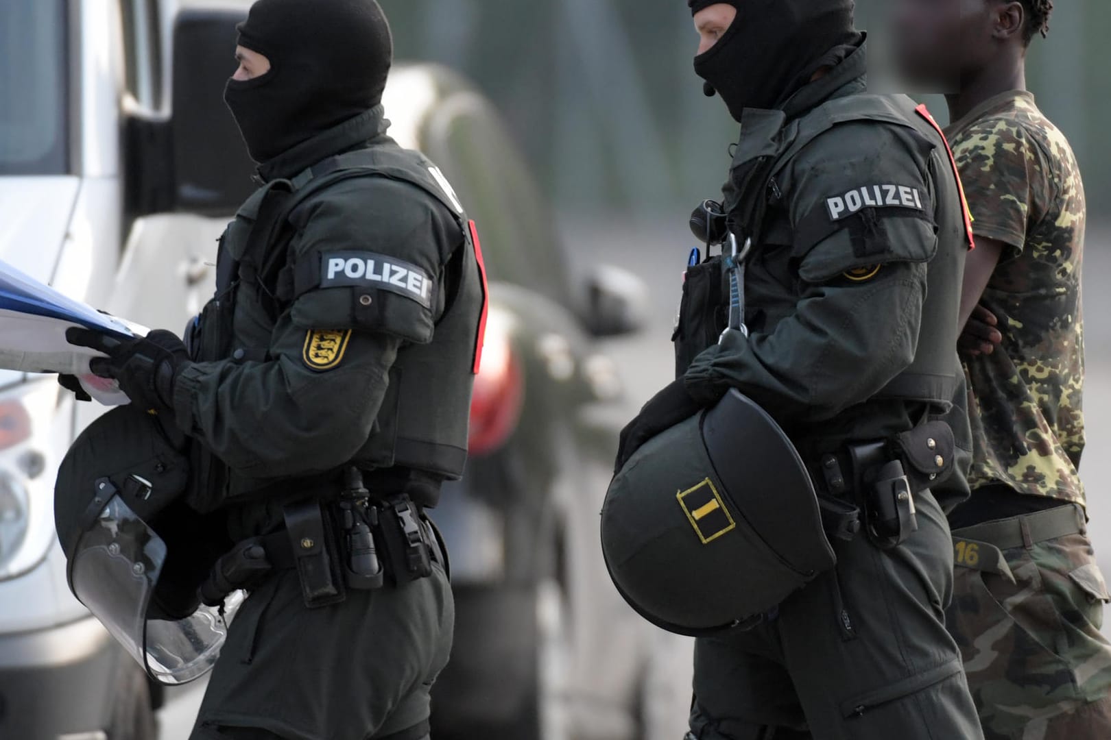 In der Flüchtlingsunterkunft in Ellwangen wird ein Mann von Polizisten eskortiert: Weil eine Abschiebung von Flüchtlingen verhindert wurde, musste die Polizei mit einem Großaufgebot zum Asylheim ausrücken.