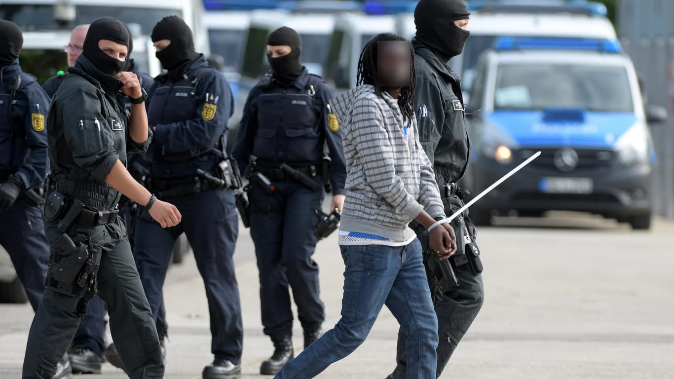 Großeinsatz in Ellwangen: Maskierte Polizisten begleiten einen in Gewahrsam genommenen Mann.