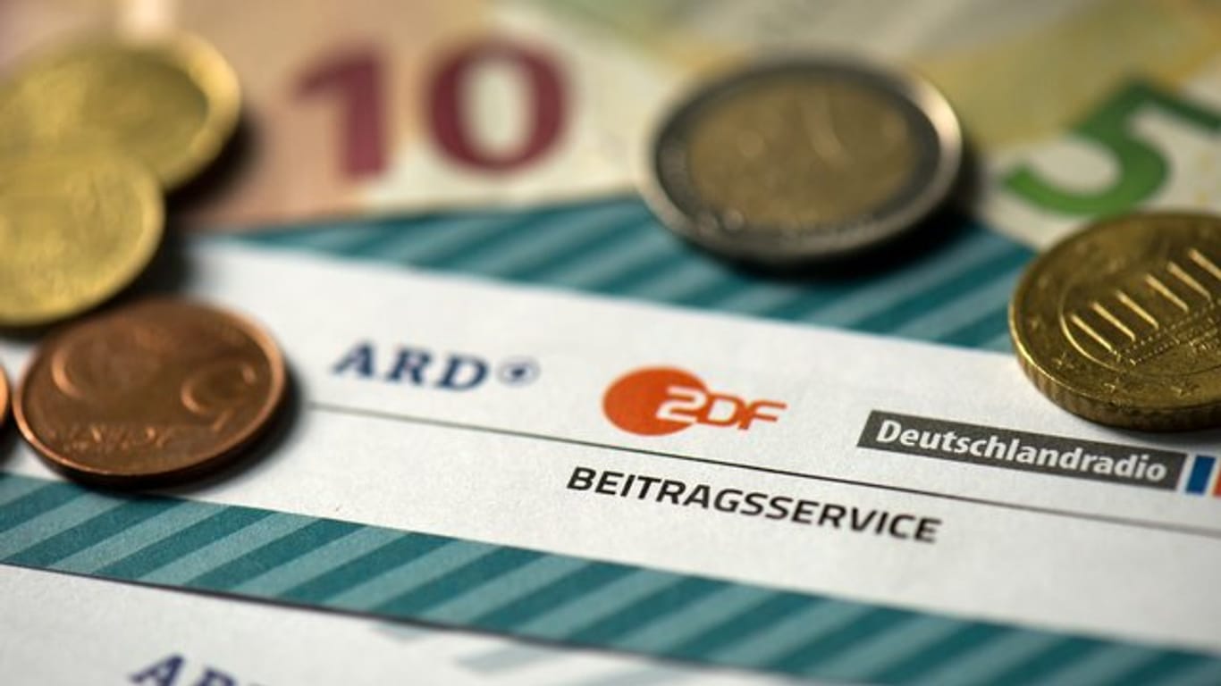 Münzgeld auf Formularen für den Rundfunkbeitrag von ARD, ZDF und Deutschlandradio.