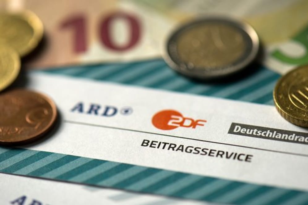 Münzgeld auf Formularen für den Rundfunkbeitrag von ARD, ZDF und Deutschlandradio.