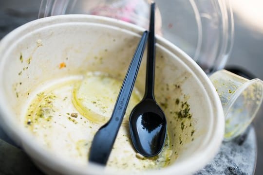 Plastikgeschirr in einem Mülleimer.