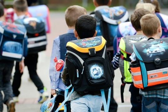 Erstklässler gehen mit ihren Ranzen und Zuckertüten zum ersten Mal in ihre Grundschule.